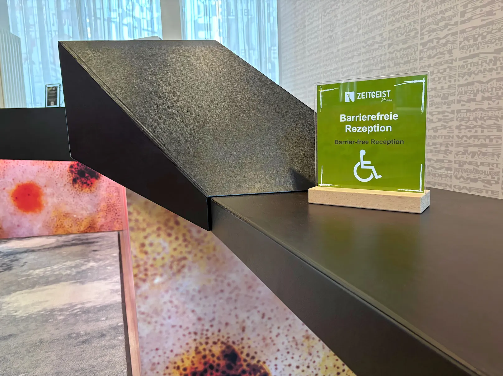 Schild „Barrierefreie Rezeption“ am Empfang