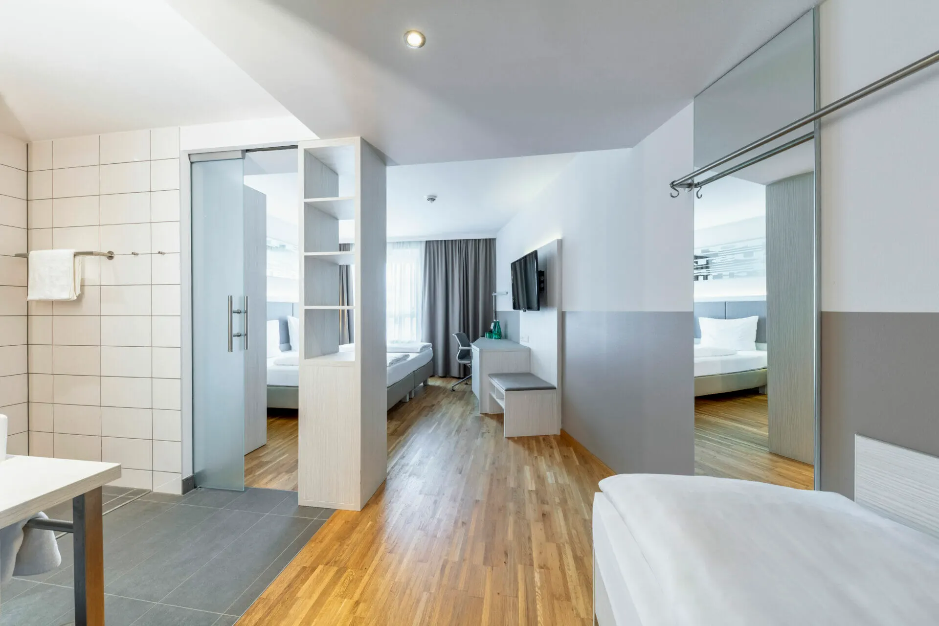 Deluxe Plus Dreibettzimmer: Blick vom Bad mit Dusche ins Zimmer
