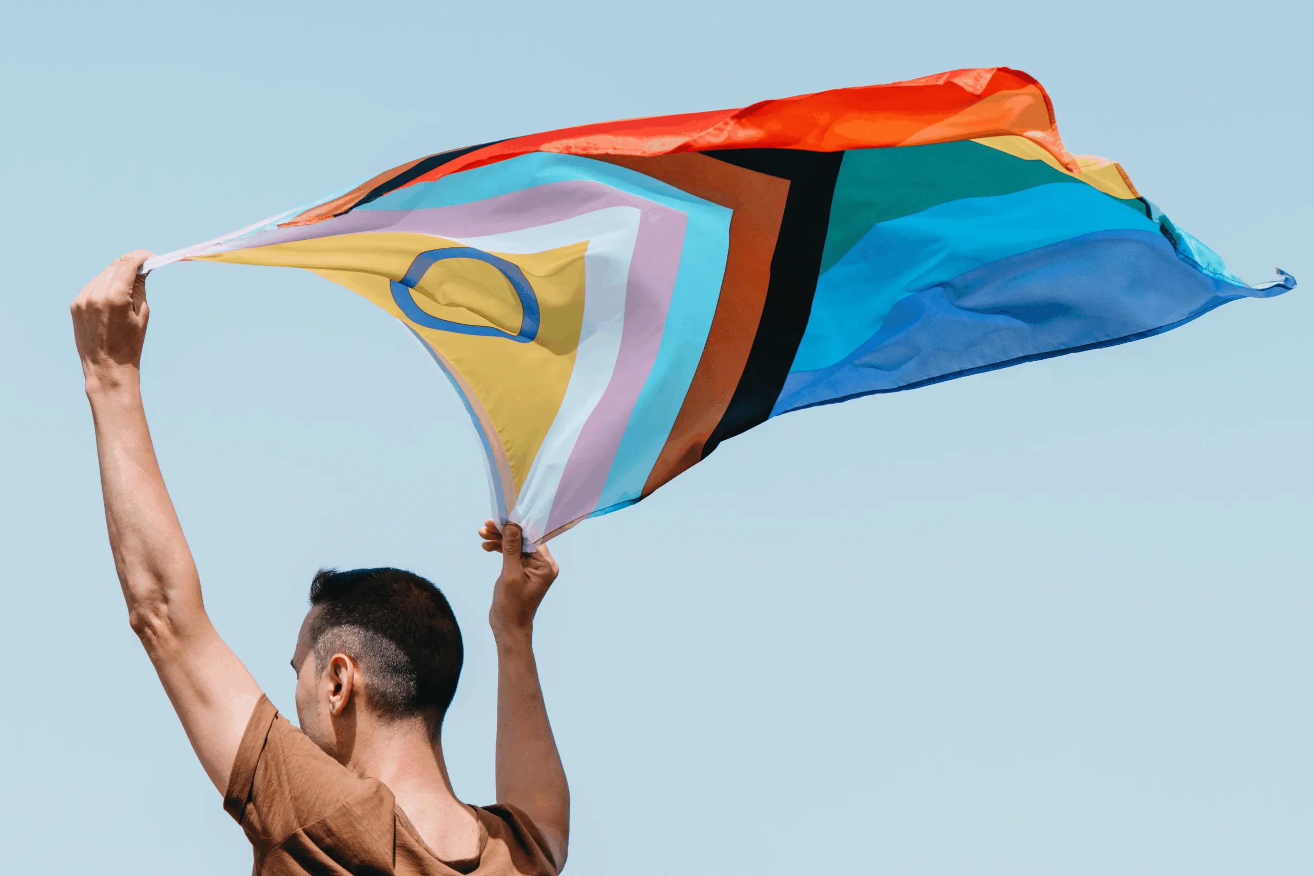 Regenbogenfahne vor blauem Himmel