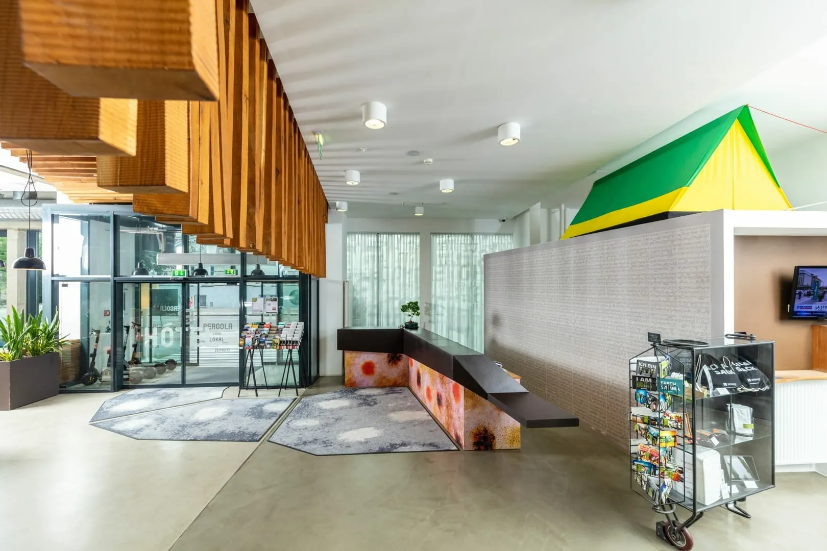 Die Lobby des Zeitgeist Vienna mit Pergola, Forellen-Front und Secrets-Wagen