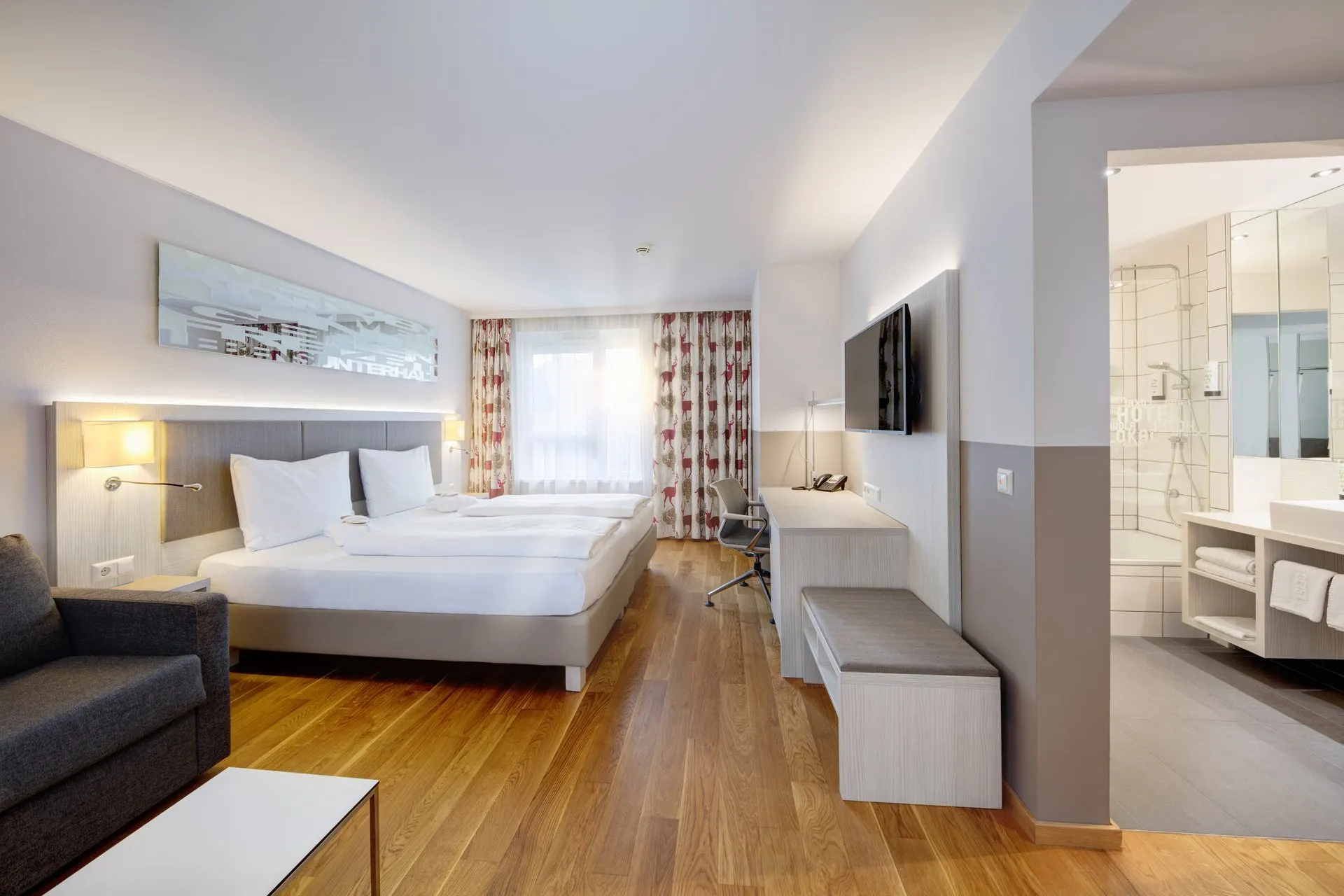 Loft: King-Size-Bett, Sessel und Schreibtisch, rechts der Blick ins Bad