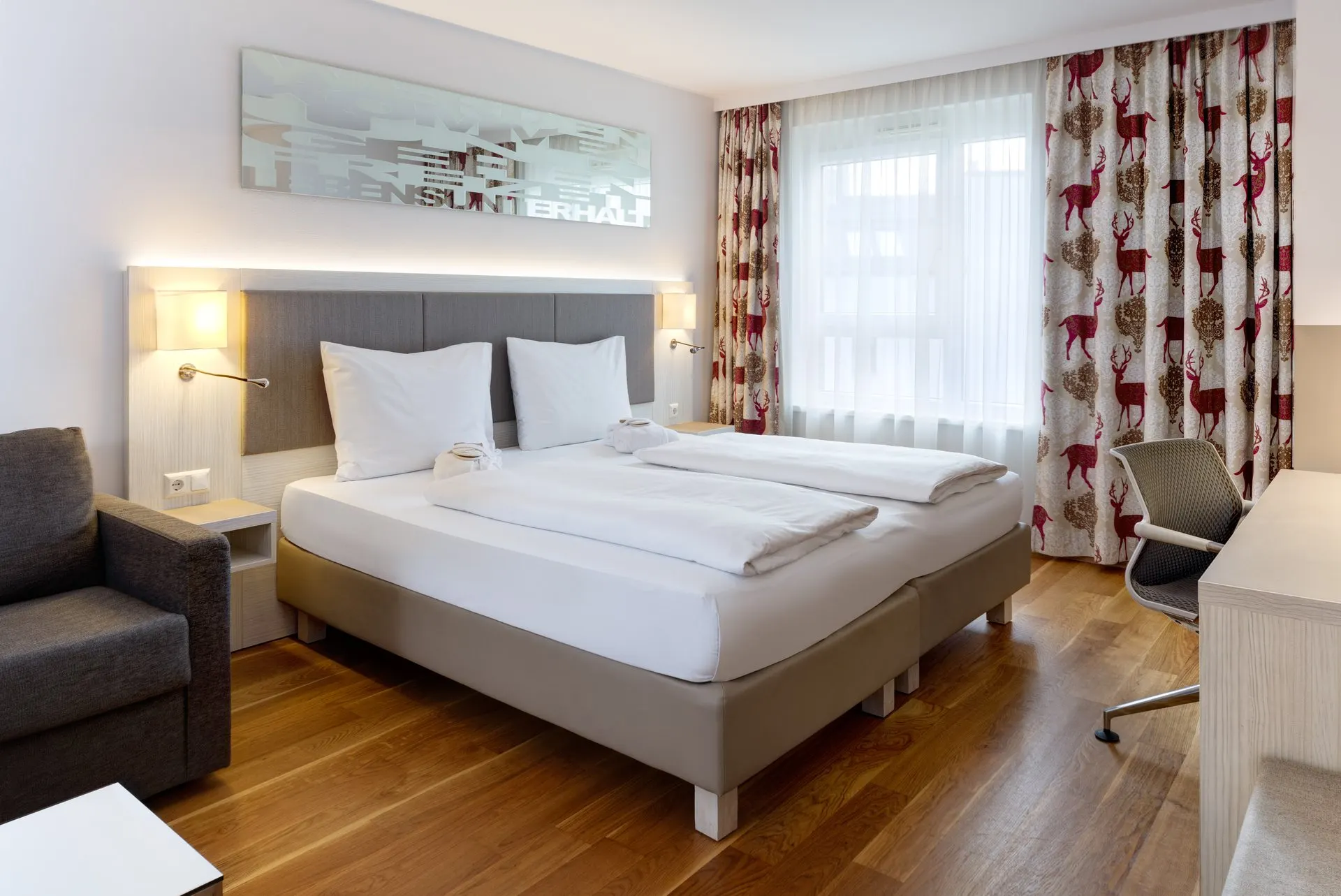 Loft: King-Size-Bett mit Leselampen, Sessel und Schreibtisch am Fenster