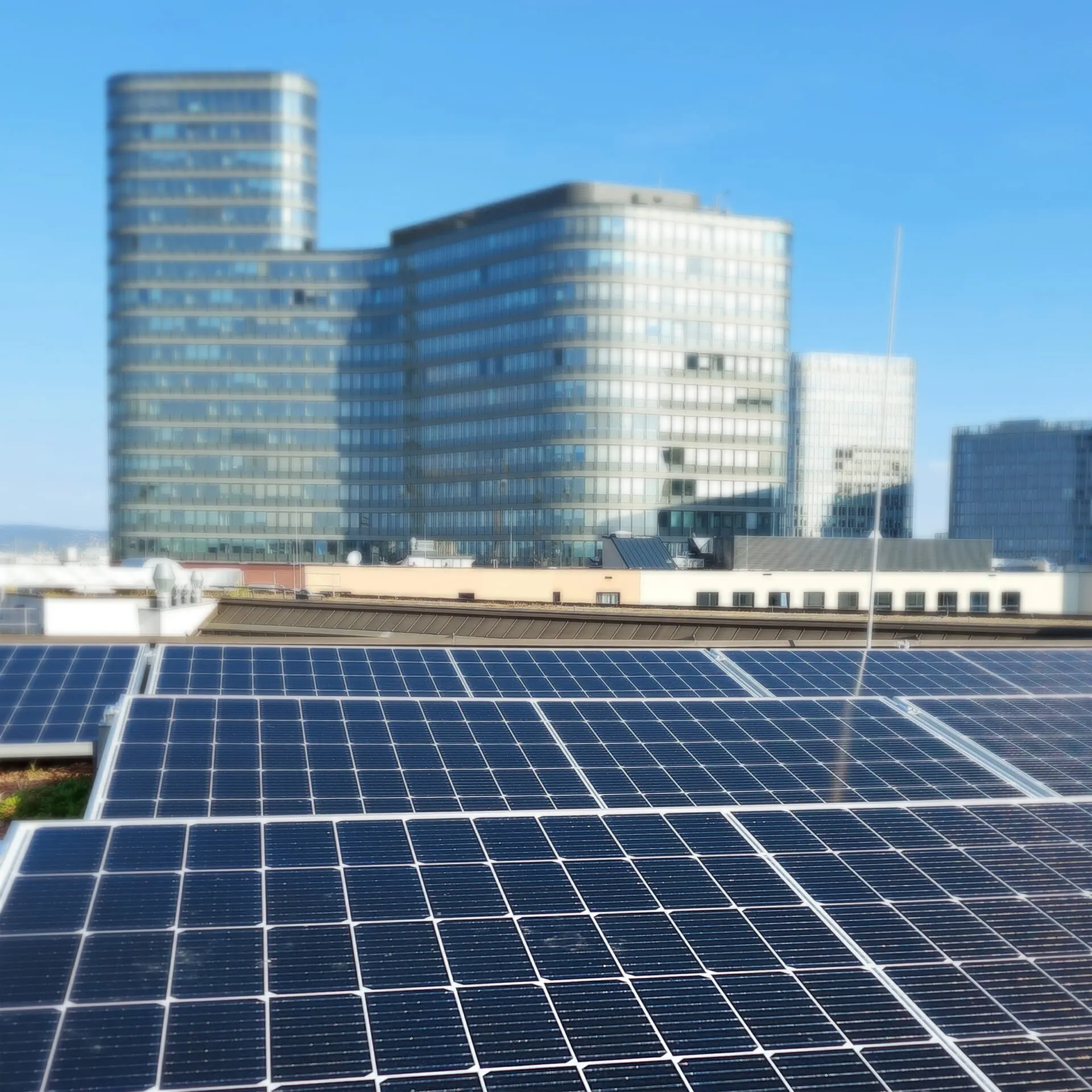Solarmodule auf dem Hoteldach, dahinter die Türme am Hauptbahnhof