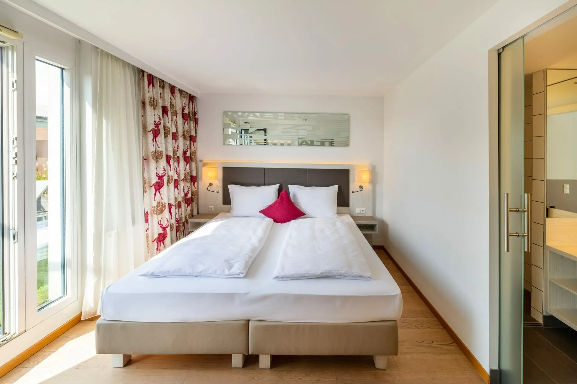 Suite mit Terrasse: Schlafzimmer mit Doppelbett und Glasschiebetür zum Bad