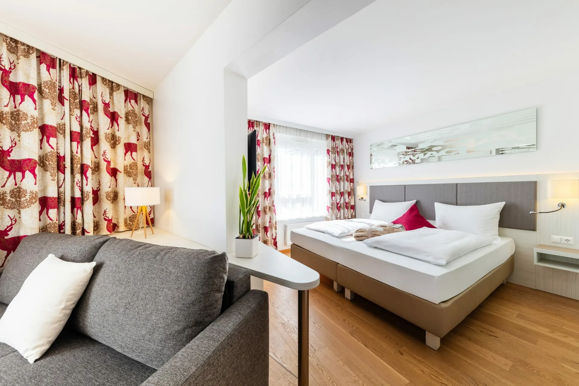 Suite: Sofa im Wohnraum, dahinter das Doppelbett