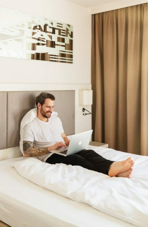 Gast arbeitet im Bett im Zeitgeist Vienna Hotel